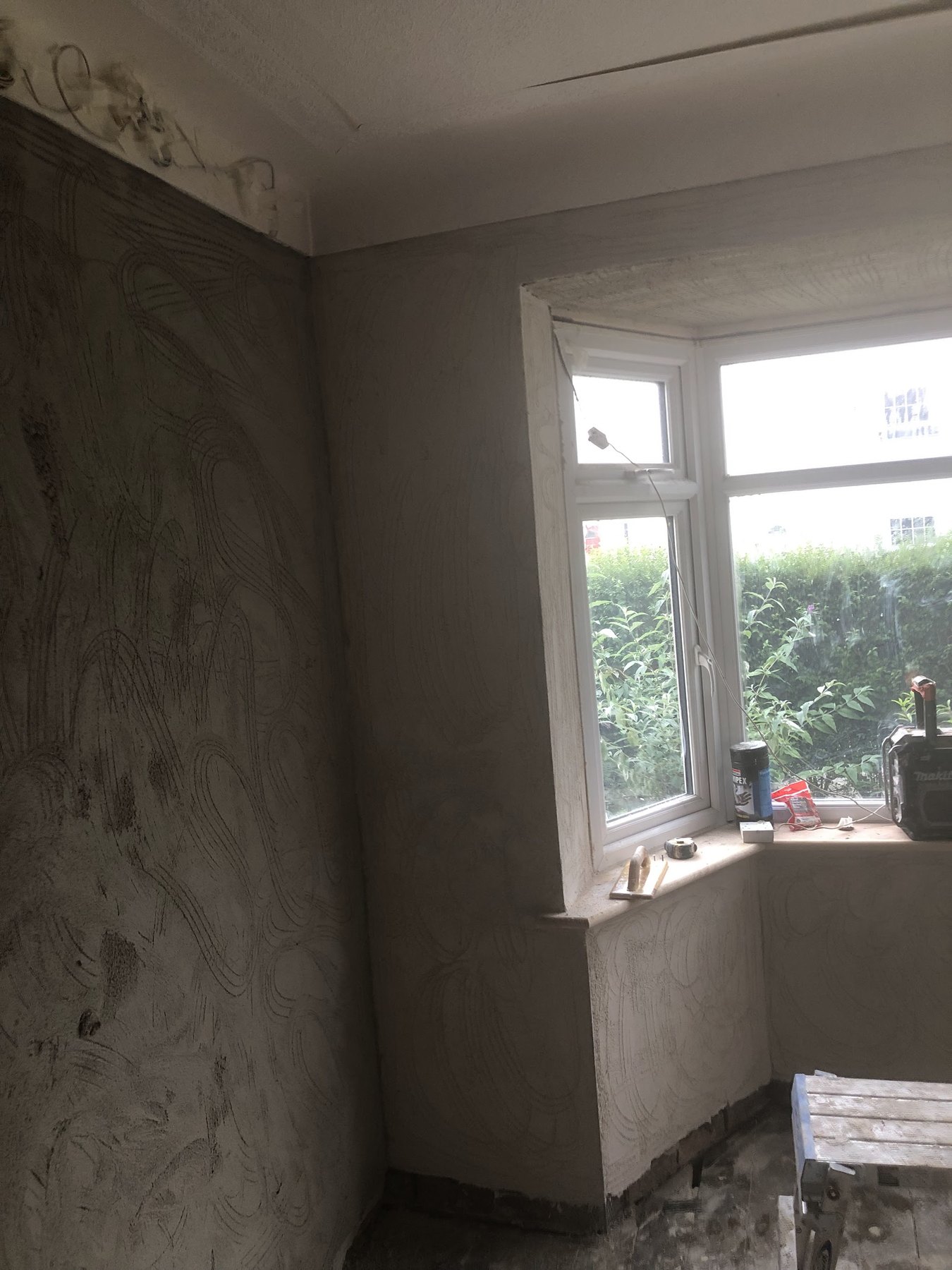 A side wall scratched in swirls, ready for the next coat