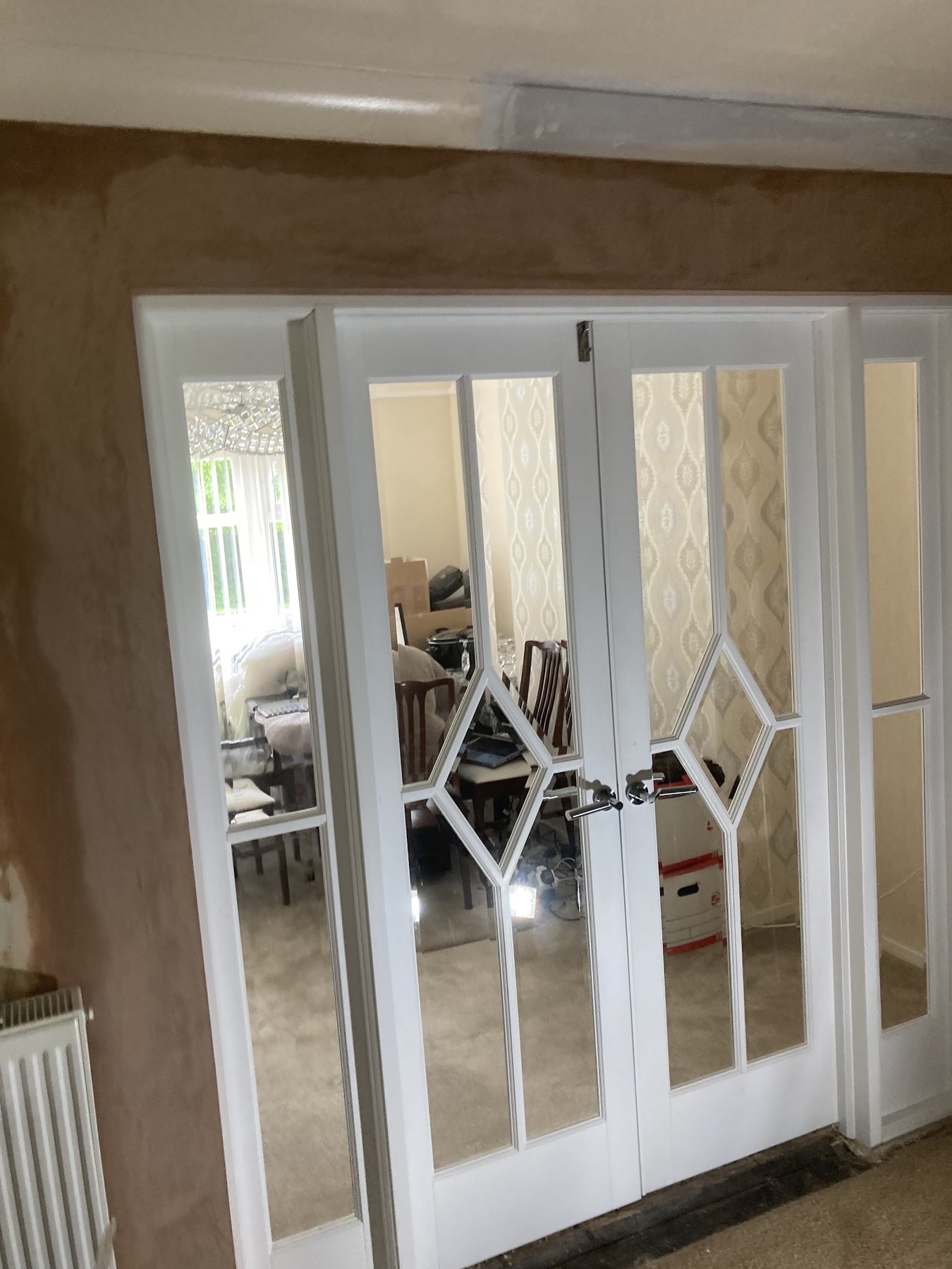 The whole wall around the white glazed doors freshly plastered